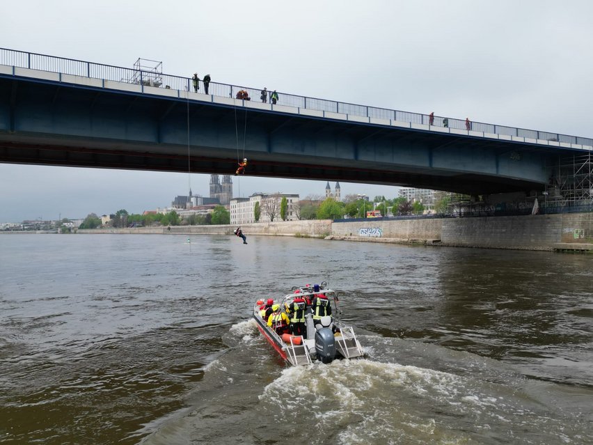 Boot mit Rettungsmannschaft fährt auf die Brücke zu um eine Rettungsübung durchzuführen.