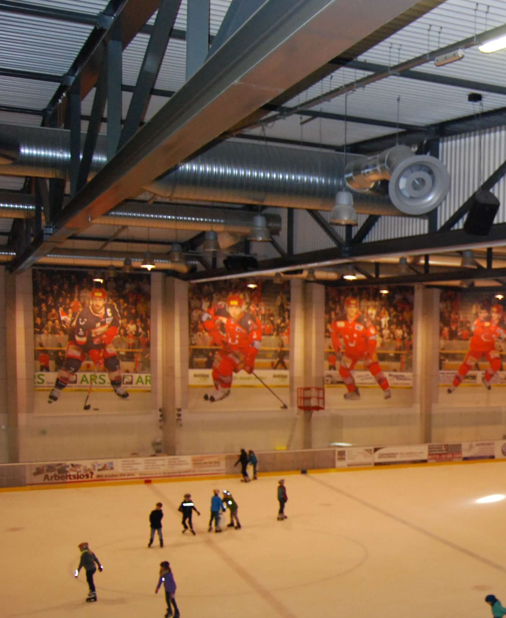 Innenansicht der Eissporthalle mit Schlittschuhläufern