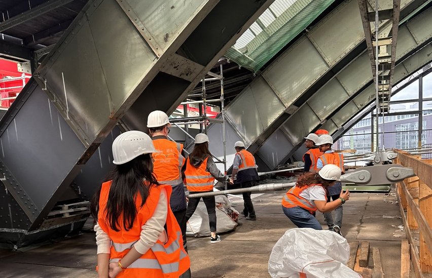 Studierende schauen sich die Stahlträger an.