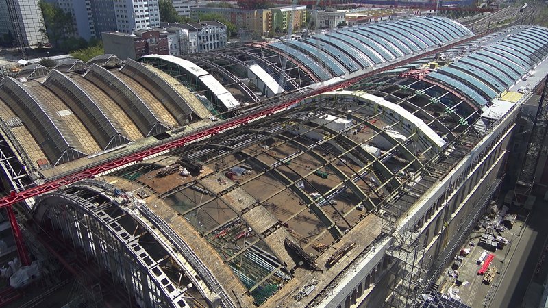 Blick von oben auf zwei teilverglaste Hallendächer des Berliner Ostbahnhofs. 