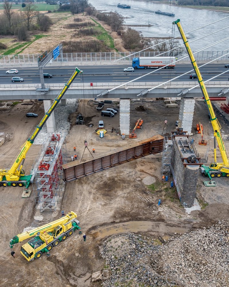 Auf der Baustelle hebt ein Kran ein altes Brückenelement.