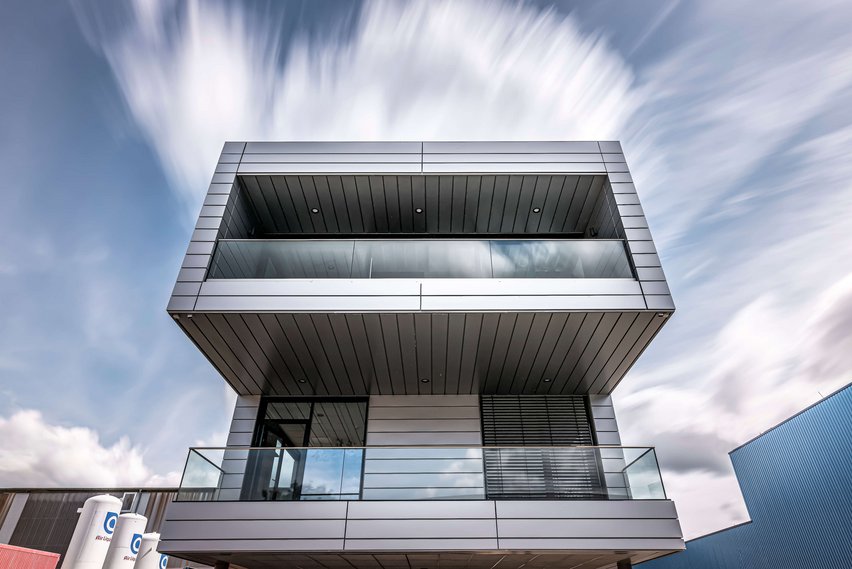 Fronansicht des modernen Bürogebäudes. Zusehen sind ein Balkon und die markanten Konturen des Gebäudes.