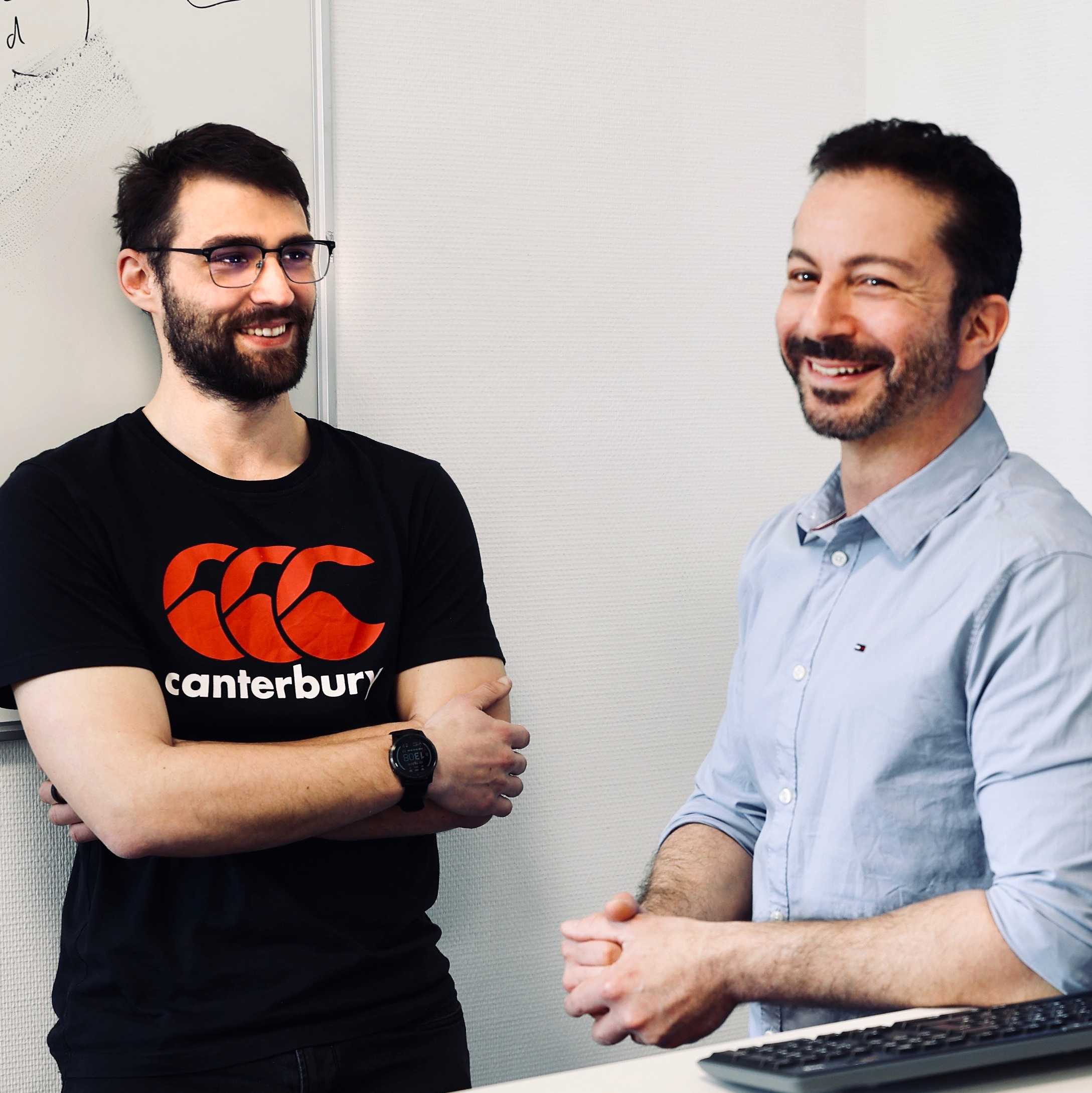 Locker gekleidete Mitarbeiter mit Bart, lachend im Porträt