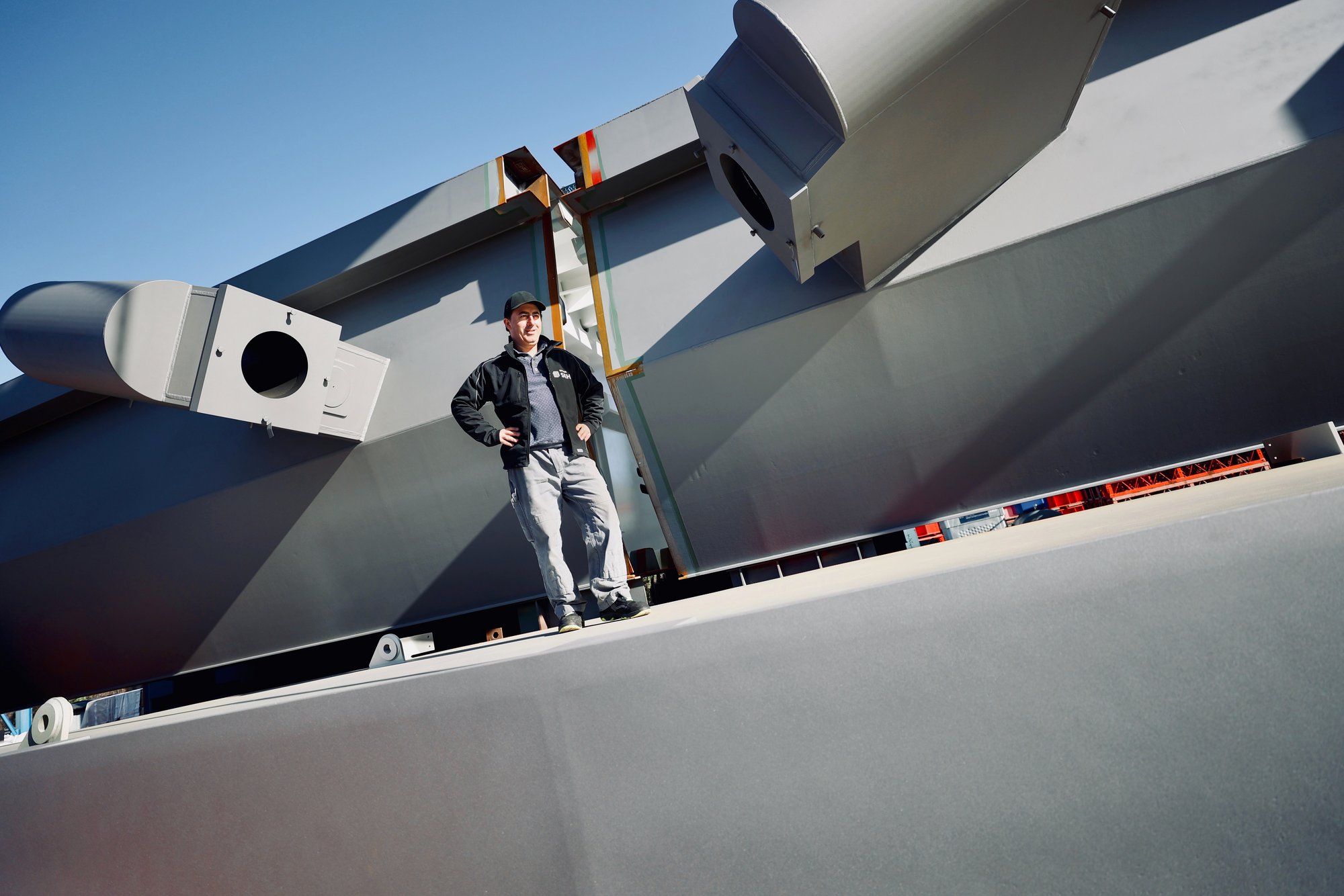 Mitarbeiter posiert vor Transportwagen