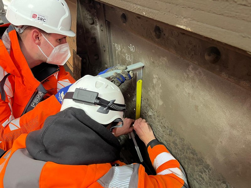 Zwei Mitarbeiter führen Messungen durch.